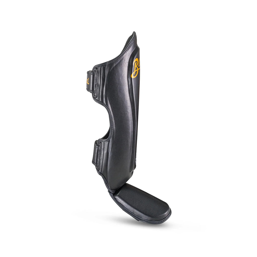 Blegend Shinguards Black: leather shin guard with gold accents and strap